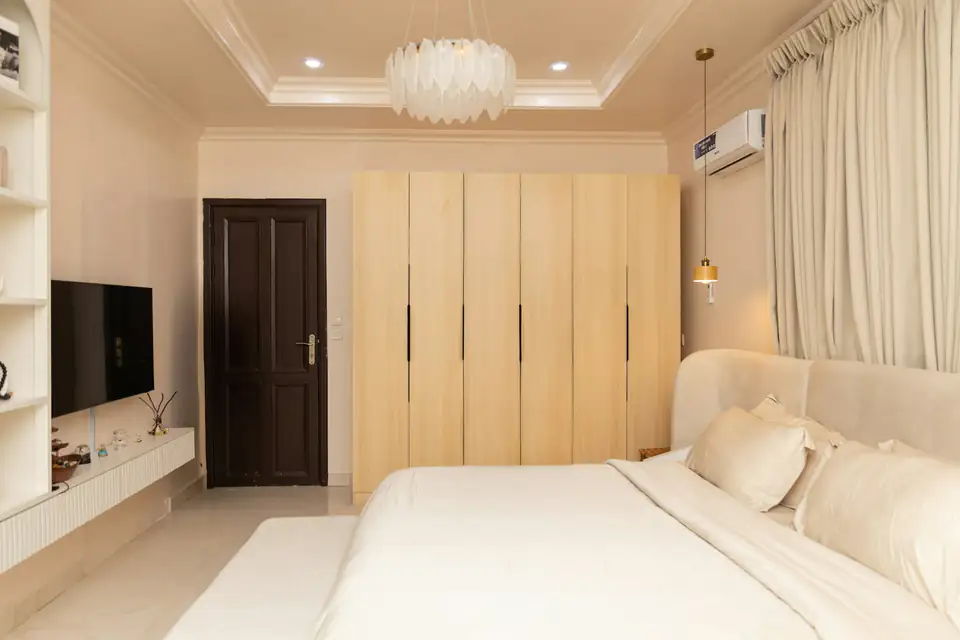 Floor-to-ceiling light wood wardrobe | Fitted wardrobes Newcastle Calm cream bedroom with a floor-to-ceiling light wood fitted wardrobe wall, a fitted wardrobe idea for Newcastle homes