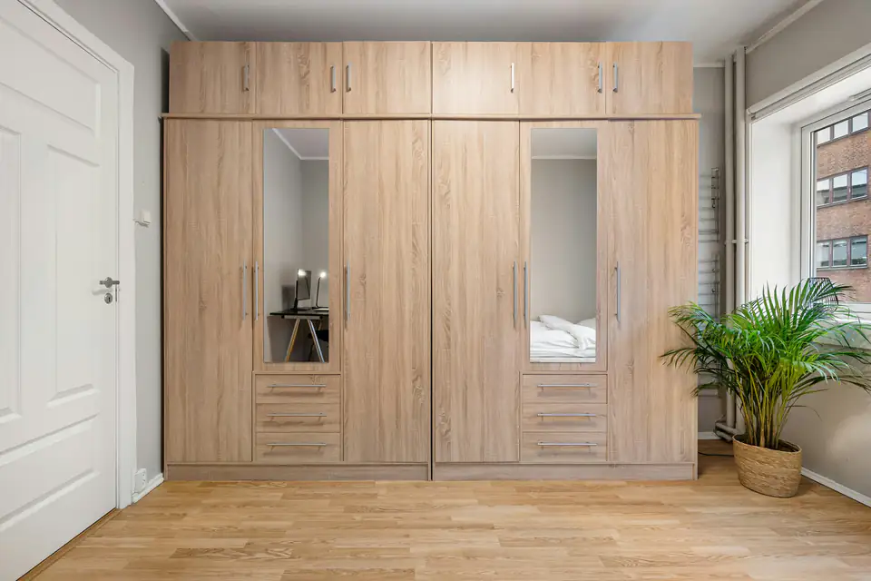 Oak wardrobe with mirror doors | Fitted wardrobes Sunderland Oak hinged fitted wardrobe with full-length mirror doors in a bedroom, a fitted wardrobe idea for Sunderland homes