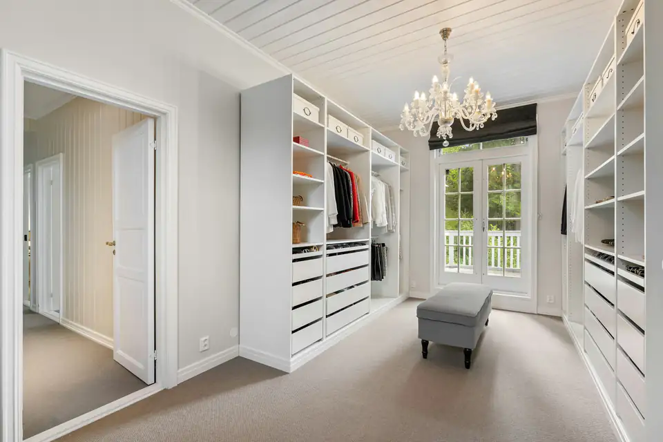 White dressing room with open shelving, a chandelier and window, design inspiration for bedrooms in Newcastle